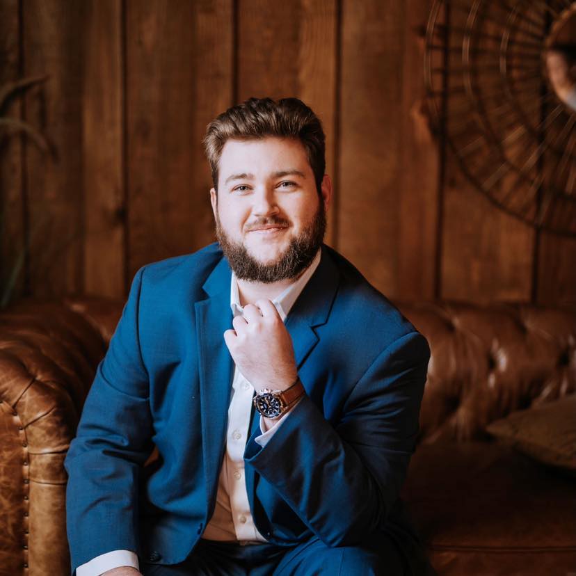 Brooks Brown, EA, Tax Strategist, seated in a blue suit